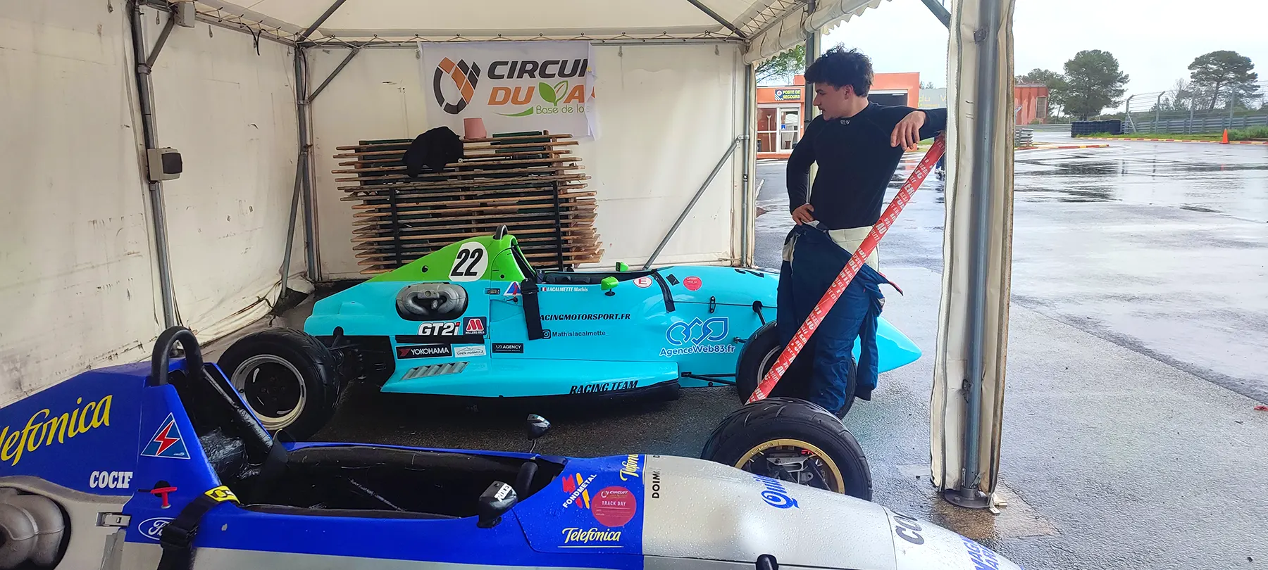 mathis-lacalmette-formule-ford-paddock-circuit-du-luc-session-10-mars-2026 Mathis Lacalmette observant sa Formule Ford dans le paddock du Circuit du Var Le Luc avant une session d’essai sous la pluie le 10 mars 2026